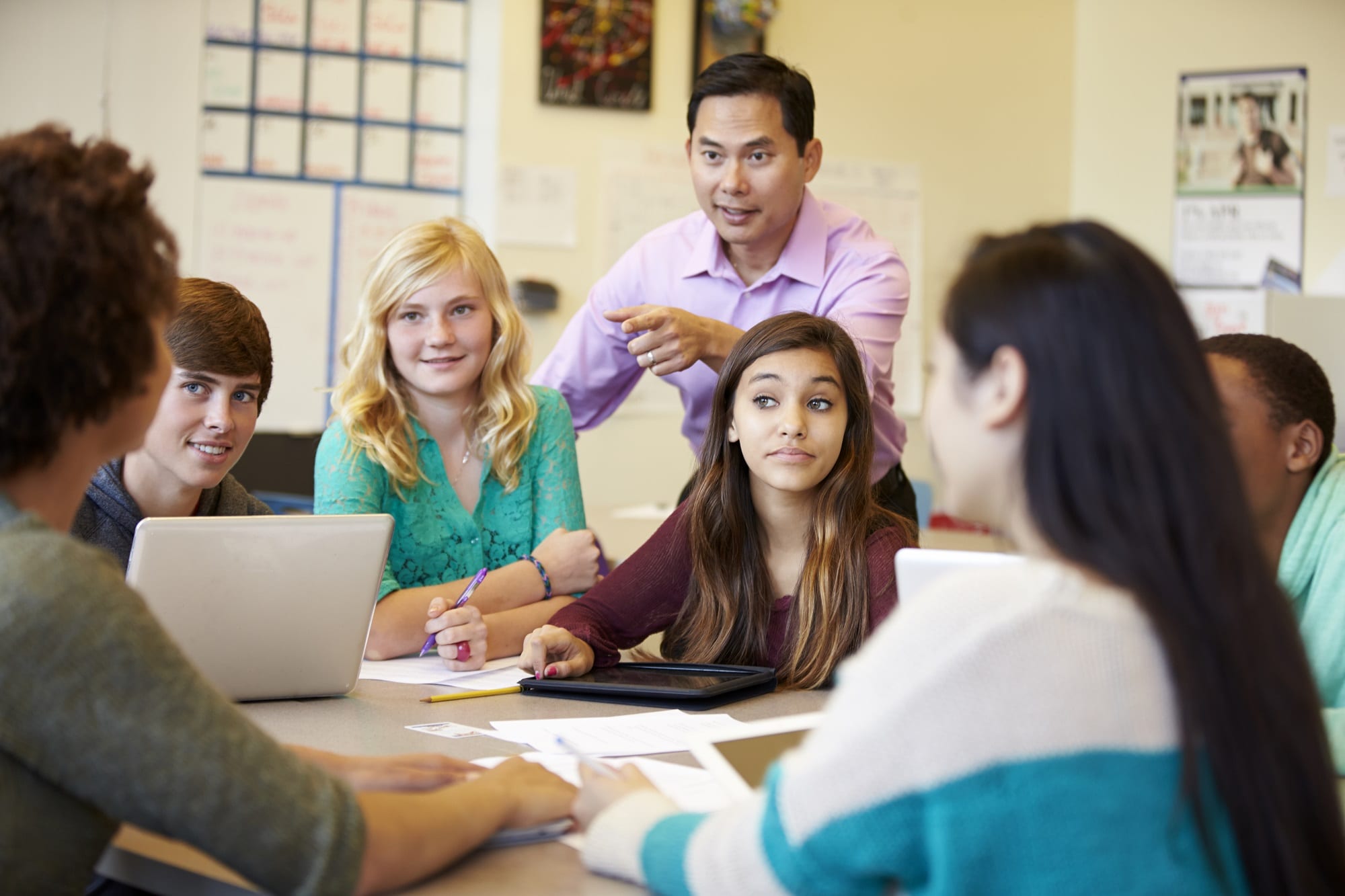High School Students With Teacher In Class Using Laptops
