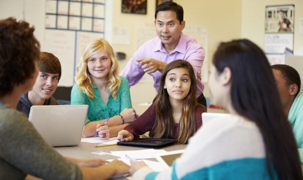 High School Students With Teacher In Class Using Laptops