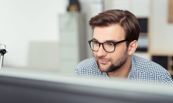 Businessman At His Desk Facing The Computer Screen