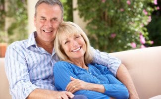 Senior Couple Relaxing On Sofa At Home