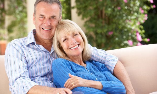 Senior Couple Relaxing On Sofa At Home