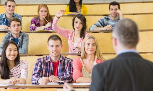 Rear View Of An Elegant Teacher With Students Sitting At The College Lecture Hall